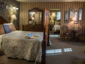 bedroom with 4 poster bed, brown striped wallpaper