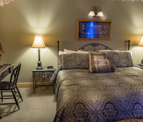 bed with brown bedspread, desk and chair